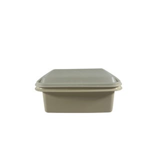 May include: A square, light beige plastic food storage container with a matching lid. The container features a smooth, matte finish and a slightly recessed base, while the lid sits securely on top with a visible rim extending around the edges.