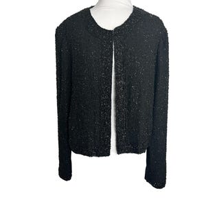 May include: A black beaded cardigan with a round neckline and long sleeves. The cardigan is open in the front and has a beaded trim around the neckline, cuffs, and hem.