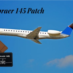 May include: Embraer 145 Patch. A white Embraer 145 airplane flies against a blue sky with white clouds. Two patches are shown below the plane. One is brown with the text "Embraer 145" and the other is black with the text "Embraer 145" and a small silhouette of the plane.