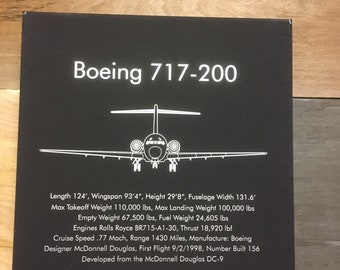 Op de afbeelding: Een zwart-witte illustratie van een Boeing 717-200 vliegtuig met technische specificaties die eronder staan. De specificaties omvatten lengte, spanwijdte, hoogte, rompbreedte, maximaal startgewicht, maximaal landingsgewicht, leeggewicht, brandstofgewicht, motoren, stuwkracht, kruissnelheid, bereik, fabrikant, ontwerper, datum van de eerste vlucht en aantal gebouwde vliegtuigen. De tekst vermeldt ook dat het vliegtuig is ontwikkeld uit de McDonnell Douglas DC-9.