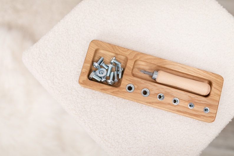 May include: A wooden tray with a compartment for screws and nuts, a screwdriver with a wooden handle, and a row of holes for matching the screws and nuts.