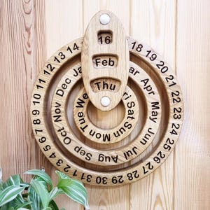 May include: A wooden perpetual calendar with rotating rings for the days, months, and days of the week. The calendar is set to February 16th, Thursday.