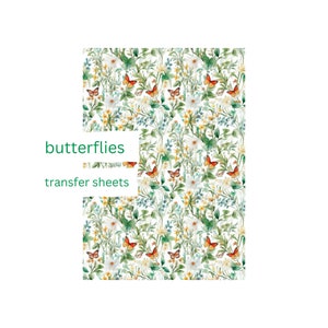 Peut inclure: Feuilles de transfert avec un motif floral à l'aquarelle. Le motif comprend des papillons orange, des fleurs blanches et du feuillage vert. Le texte "butterflies transfer sheets" est imprimé en vert. Motif répété.