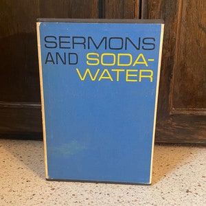 May include: A blue book with the title "SERMONS AND SODA WATER" in black and yellow lettering.