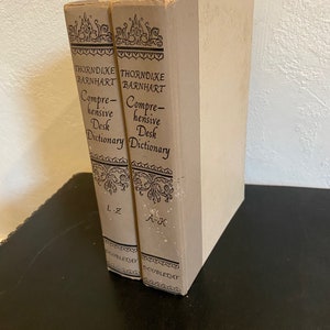 May include: Two hardback books, side by side, with tan covers and black text. The books are titled "Thorndike Barnhart Comprehensive Desk Dictionary" and are labelled "L-Z" and "A-K".