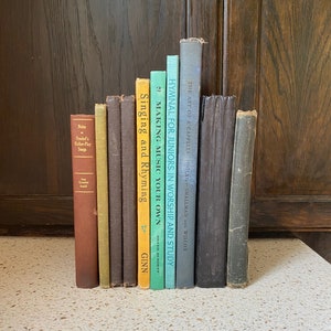 Könnte beinhalten: Eine Sammlung von alten Büchern mit bunten Rücken, darunter Titel wie "Hymnal for Juniors in Worship and Study", "Making Music Your Own" und "Singing and Rhyming".