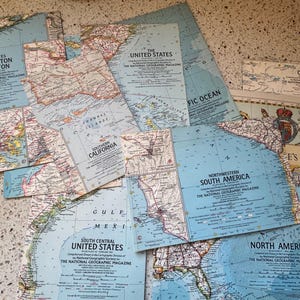 May include: A collection of vintage maps from The National Geographic Magazine, featuring areas like Washington to Boston, Southern California, and North America. The maps have a blue and beige color scheme.
