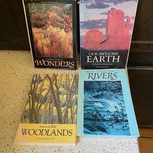 May include: Four National Geographic Society books. Titles include "Nature's World of Wonders," "Our Awesome Earth," "America's Wild Woodlands," and "America's Wild and Scenic Rivers." The books feature images of natural landscapes.