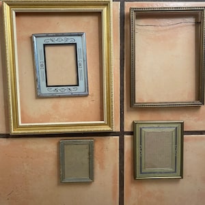 Op de afbeelding: Collectie vintage fotolijsten in diverse maten en stijlen. Inclusief gouden, zilveren en bronzen lijsten, sommige met sierlijke details. De lijsten zijn leeg, klaar voor foto's of kunstwerken.