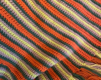 May include: A striped crocheted throw blanket with a fringe border in shades of orange, green, yellow, and purple.