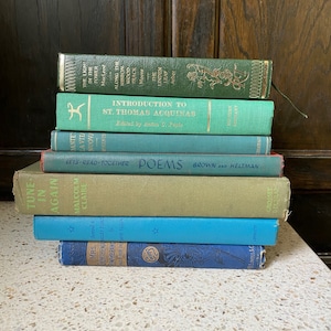 K&ouml;nnte beinhalten: Ein Stapel von acht alten gebundenen B&uuml;chern mit gr&uuml;nen, blauen und roten Einb&auml;nden. Die B&uuml;cher haben Titel wie "The Light in the Tower", "Introduction to St. Thomas Aquinas", "Let's Read Together Poems", "Tune in Again" und "Mrs. Ferthewalley Forge".