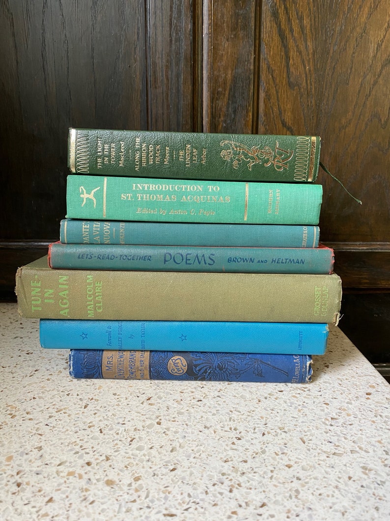 K&ouml;nnte beinhalten: Ein Stapel von acht alten gebundenen B&uuml;chern mit gr&uuml;nen, blauen und roten Einb&auml;nden. Die B&uuml;cher haben Titel wie "The Light in the Tower", "Introduction to St. Thomas Aquinas", "Let's Read Together Poems", "Tune in Again" und "Mrs. Ferthewalley Forge".