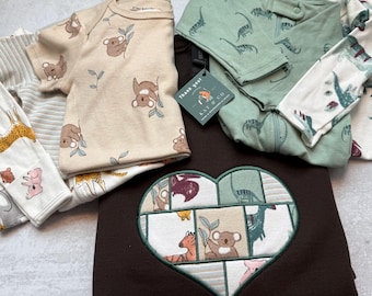 Könnte beinhalten: Eine Auswahl an Babykleidung, darunter ein braunes Sweatshirt mit einem herzförmigen Patchwork-Design. Der Patchwork-Bereich zeigt verschiedene Tiermuster. Weitere Artikel sind ein beiger Strampler mit Koala-Prints und grüne Schlafanzüge mit Dinosaurier-Muster.