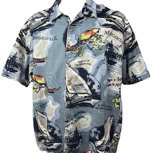 Pode incluir: Uma caneca de cerâmica branca com uma alça preta e o texto "But First, Coffee" em preto, em negrito. A caneca está sobre uma superfície de madeira. A caneca tem aproximadamente 10 cm de altura.