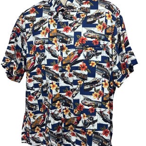 May include: Short-sleeved button-down shirt with a navy blue and white checkered pattern. The shirt features a print of vintage airplanes and red and yellow hibiscus flowers. It has a single chest pocket and a classic collar.