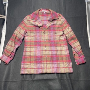 May include: A long-sleeved plaid shirt with a button-up front and a collar. The shirt is made of a soft, woven fabric and has a relaxed fit. The plaid pattern is in shades of brown, pink, and purple.