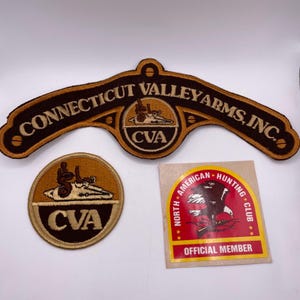 May include: Three vintage patches and a sticker. The largest patch is brown and tan with the text "CONNECTICUT VALLEY ARMS, INC." and a logo. A round patch and a sticker with "NORTH AMERICAN HUNTING CLUB" are also included.
