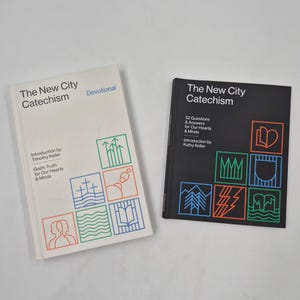 May include: Two books titled "The New City Catechism" are displayed. One has a white cover with colorful geometric designs and the word "Devotional." The other book has a black cover with colorful geometric designs and the text "52 Questions & Answers."
