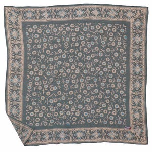 May include: A square scarf featuring a dark gray background with a repeating pattern of small white flowers and light blue centers. The border displays a geometric design with light blue and white floral motifs on a dark gray base.