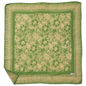 May include: A square green scarf featuring a beige floral pattern across the center and a geometric Greek key border. The fabric displays a repeating botanical design with leaves and blossoms, finished with a small white label in the corner.