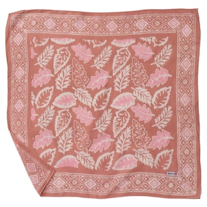 May include: A square, terracotta-colored scarf with a repeating pattern of pink and white leaves. The border features a geometric design. The scarf is made of a soft fabric and is suitable for various styling options.