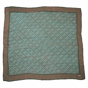 May include: Square scarf with a teal and brown geometric pattern. The scarf has a teal center with a grid-like design and a brown border with a floral pattern. The scarf is made of a soft, lightweight material.