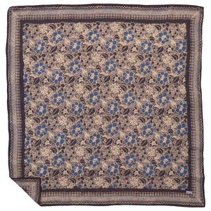 May include: A square scarf featuring a dark brown border with a repeating geometric Greek key pattern. The central field displays a dense floral print with blue and beige flowers and dark brown leaves on a beige background, with one corner folded.