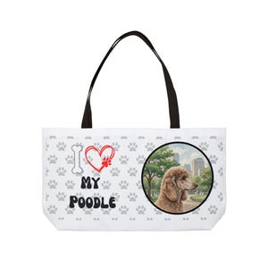 Może przedstawiać: Biała torba z czarnymi uchwytami. Torba ma wzór pudla, powtarzający się wzór łap i napis "I Love My Poodle". Okrągły obrazek przedstawia pudla w otoczeniu parku.