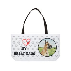 Może przedstawiać: Biała torba typu tote z czarnymi uchwytami. Zawiera ilustrację doga niemieckiego w okrągłej ramce, odciski łap i napis "I ❤️ MY GREAT DANE" w kolorze czarnym i czerwonym.