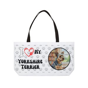 Może przedstawiać: Biała torba typu tote z czarnymi uchwytami. Zawiera ilustrację Yorkshire Terriera w okrągłej ramce. Torba ma powtarzający się wzór łap i napis "I ❤️ MY YORKSHIRE TERRIER".