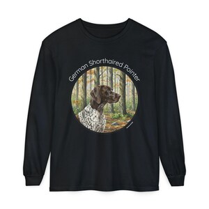 May include: Black long-sleeve shirt featuring a circular graphic of a German Shorthaired Pointer dog in a forest setting. The dog is brown and white, with the text "German Shorthaired Pointer" in a white font around the graphic.