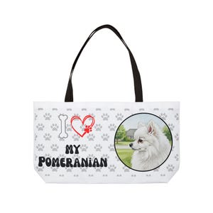 Może przedstawiać: Biała torba typu tote z czarnymi uchwytami. Zawiera ilustrację psa rasy Pomeranian w okrągłej ramce, wzór łap i napis "I ❤️ MY Pomeranian".