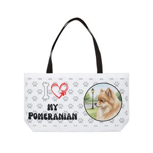 Może przedstawiać: Biała torba typu tote z czarnymi uchwytami z ilustracją psa rasy Pomeranian. Torba ma powtarzający się wzór łap i napis "I ❤️ MY POMERANIAN" z kością i grafiką łapy.