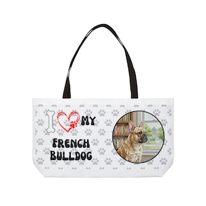 Może przedstawiać: Biała torba z czarnymi uchwytami z motywem buldoga francuskiego. Torba ma powtarzający się wzór łap i napis "I ❤️ MY FRENCH BULLDOG". Po prawej stronie znajduje się okrągły obraz buldoga francuskiego.