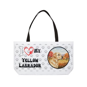Może przedstawiać: Biała torba typu tote z czarnymi uchwytami. Projekt zawiera napis "I love my yellow labrador", serce z odciskiem łapy, kość i okrągły obraz żółtego labradora na polu.