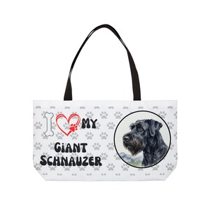 Może przedstawiać: Biała torba typu tote z czarnymi uchwytami. Zawiera ilustrację sznaucera olbrzymiego oraz napis "I ❤️ MY Giant Schnauzer" z odciskami łap i kością.