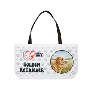 Może przedstawiać: Biała torba z czarnymi uchwytami. Torba posiada wzór Golden Retriever z napisem "I ❤️ MY GOLDEN RETRIEVER", śladami łap i grafiką kości. Okrągły obraz Golden Retrievera znajduje się po prawej stronie.