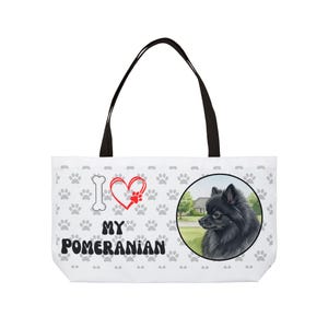 Może przedstawiać: Biała torba typu tote z czarnymi uchwytami. Zawiera ilustrację psa rasy Pomeranian w okrągłej ramce, wzór łap i napis "I ❤️ MY Pomeranian".