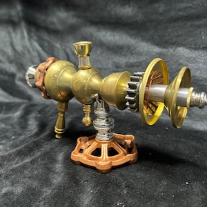 May include: A steampunk-style brass and copper pipe with a gear and a valve on a brown metal base.