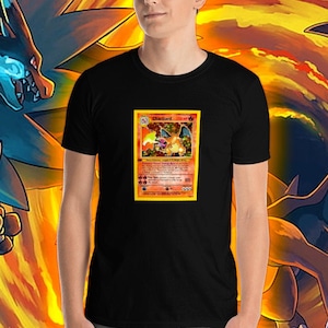 May include: A black t-shirt with a vintage Pokemon card featuring Charizard on the front. The card is surrounded by a fiery orange background.