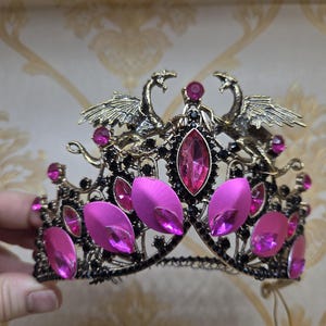 Tvillingdrakar i mässing med metallfjäll på guldtiara