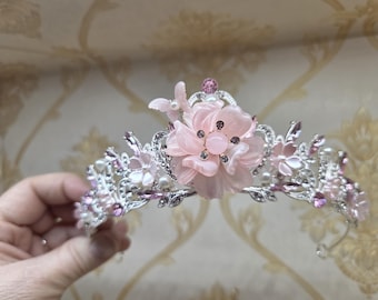 Pink flower on silver tiara with pink gems and a comb