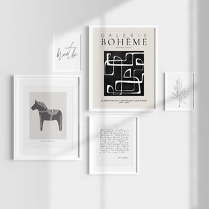 May include: A gallery wall with five framed prints. The prints feature a black and white abstract design, a black and white illustration of a horse, a handwritten note, a simple line drawing of a branch, and the text "breathe".