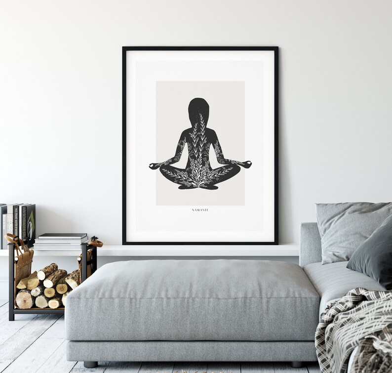 Puede incluir: Impresi&oacute;n en blanco y negro de una persona en una postura de yoga con detalles florales. La impresi&oacute;n est&aacute; enmarcada en un marco negro y el texto "NAMASTE" est&aacute; en la parte inferior de la impresi&oacute;n.