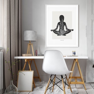 Puede incluir: Una ilustraci&oacute;n en blanco y negro de una persona en una postura de yoga con la palabra "Namaste" en la parte inferior de la imagen. La ilustraci&oacute;n est&aacute; enmarcada y colgada en una pared blanca.