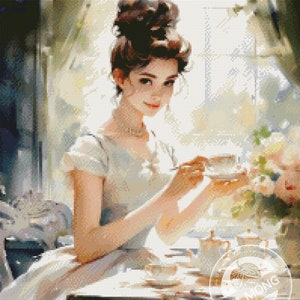 May include: A woman in a light blue dress sits at a table with a cup of tea and a teapot. She is wearing a pearl necklace and has her hair pulled back in a bun. The table is set with a white tablecloth and a floral arrangement.