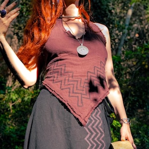 May include: A dark brown sleeveless top with a raw-edge hem and a black zigzag pattern, paired with a black skirt featuring a matching zigzag print. The outfit is accessorised with a silver-toned circular pendant necklace and a silver-toned choker.
