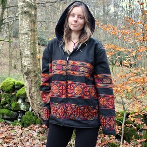May include: A black hooded jacket with a colourful geometric pattern. The jacket has a zip closure and long sleeves.