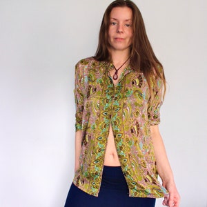 Op de afbeelding: Een lang mouw overhemd met knopen en een paisley print in tinten van groen, bruin en blauw. Het overhemd heeft een kraag en een knoopsluiting aan de voorkant.