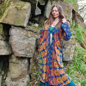 May include: A long, blue and orange patterned kimono with a floral design. The kimono is open in the front and has a belt.